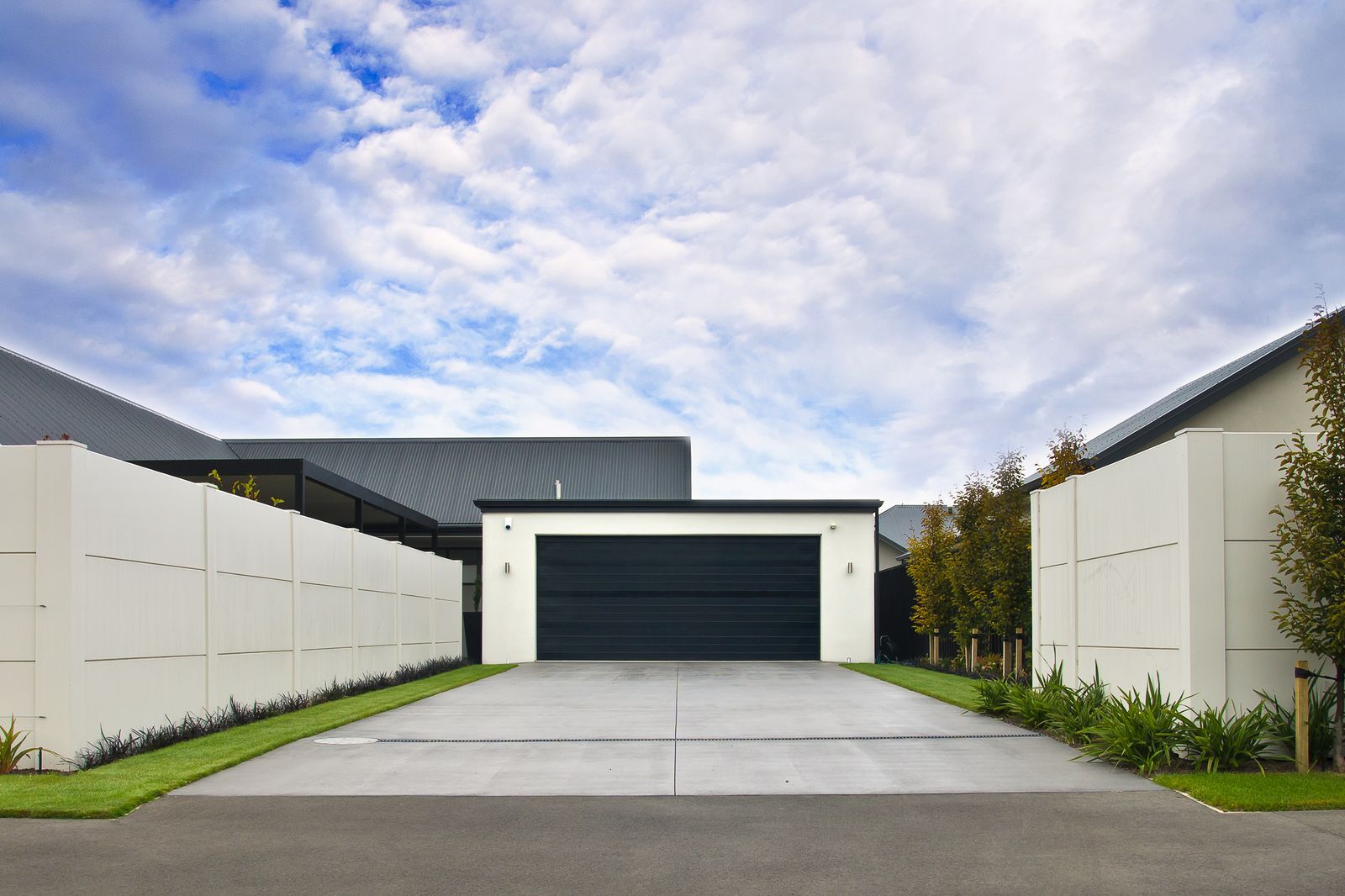 Black insulated sectional garage door installed on a modern home — manufactured by Sunotech, China